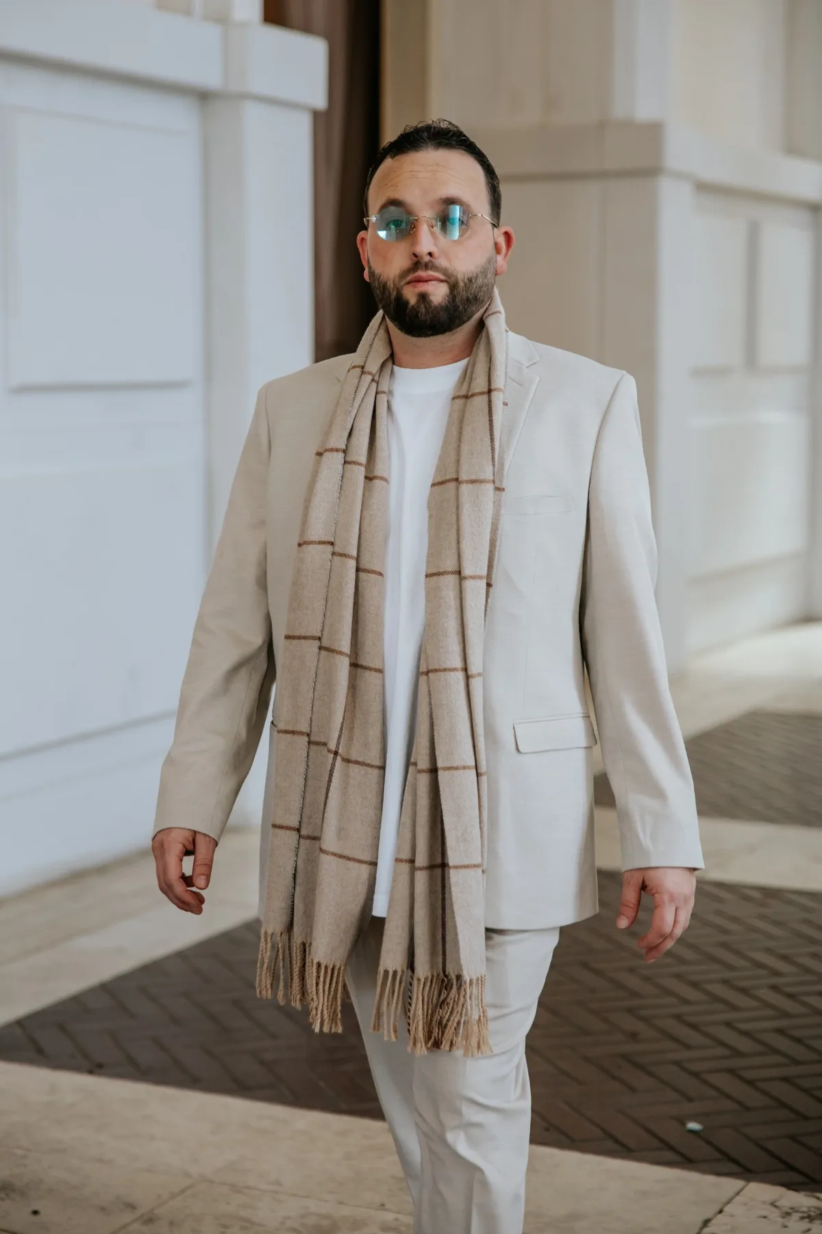 Meir Margalit, founder and leader of Diamond Productions, in a light suit and scarf