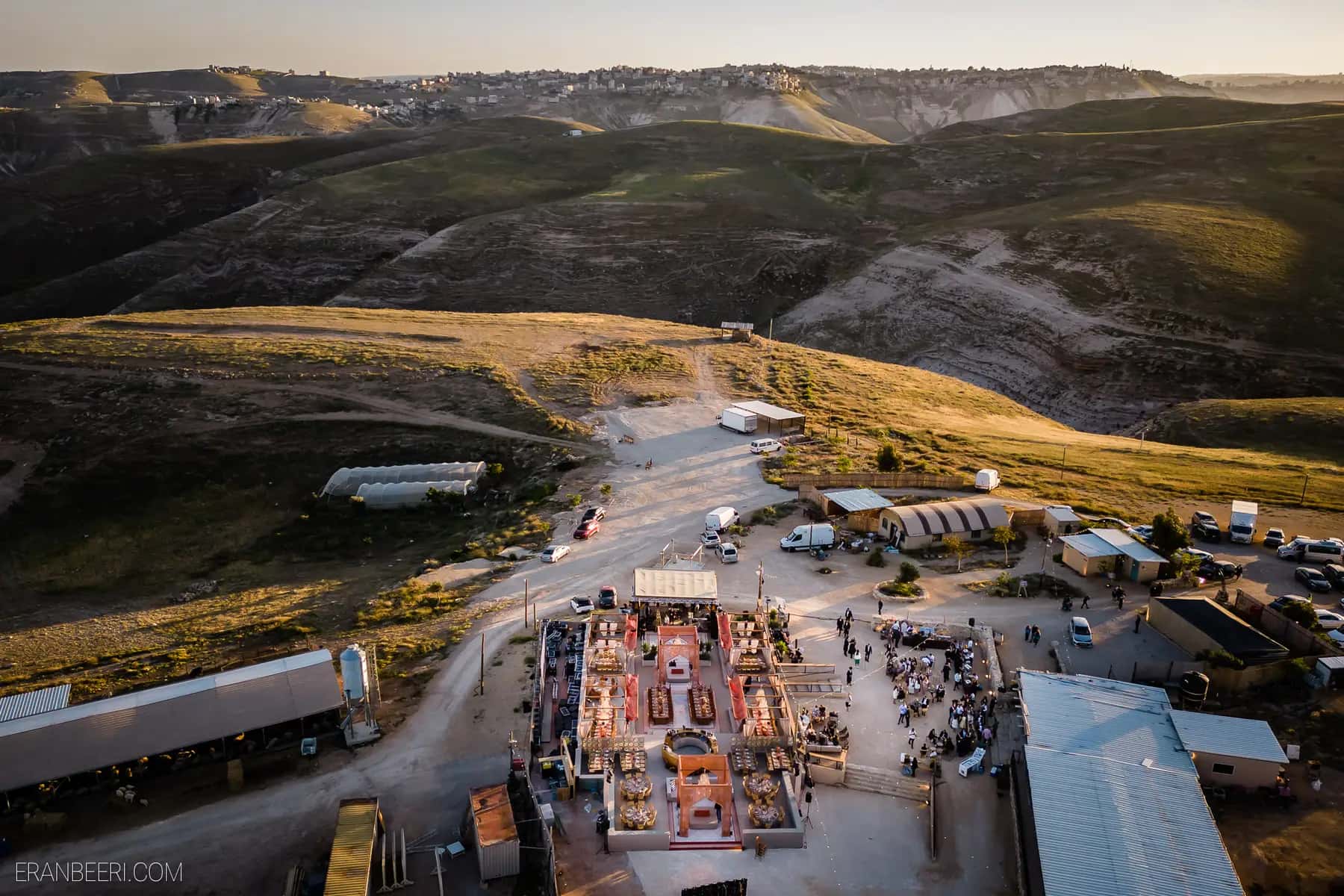 מבט מלמעלה על מתחם אירוע בנוף מדברי בשעת שקיעה