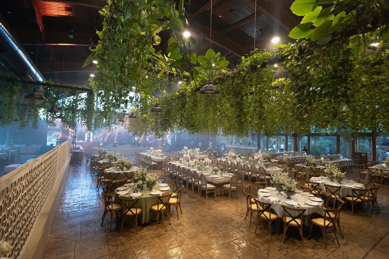 Space styled with hanging green branches above the tables